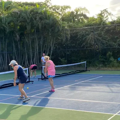 a group of people on a court with a racket