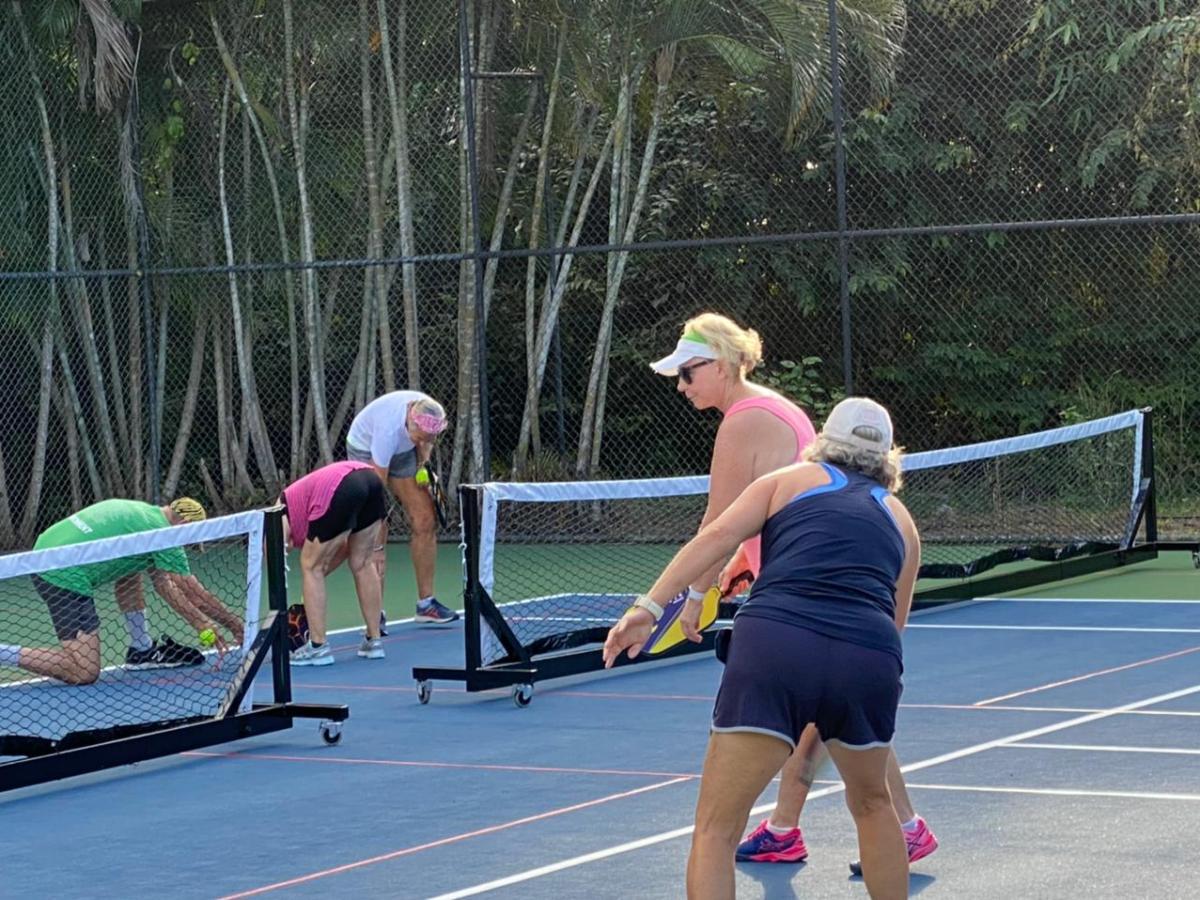 a group of people on a court with a racket