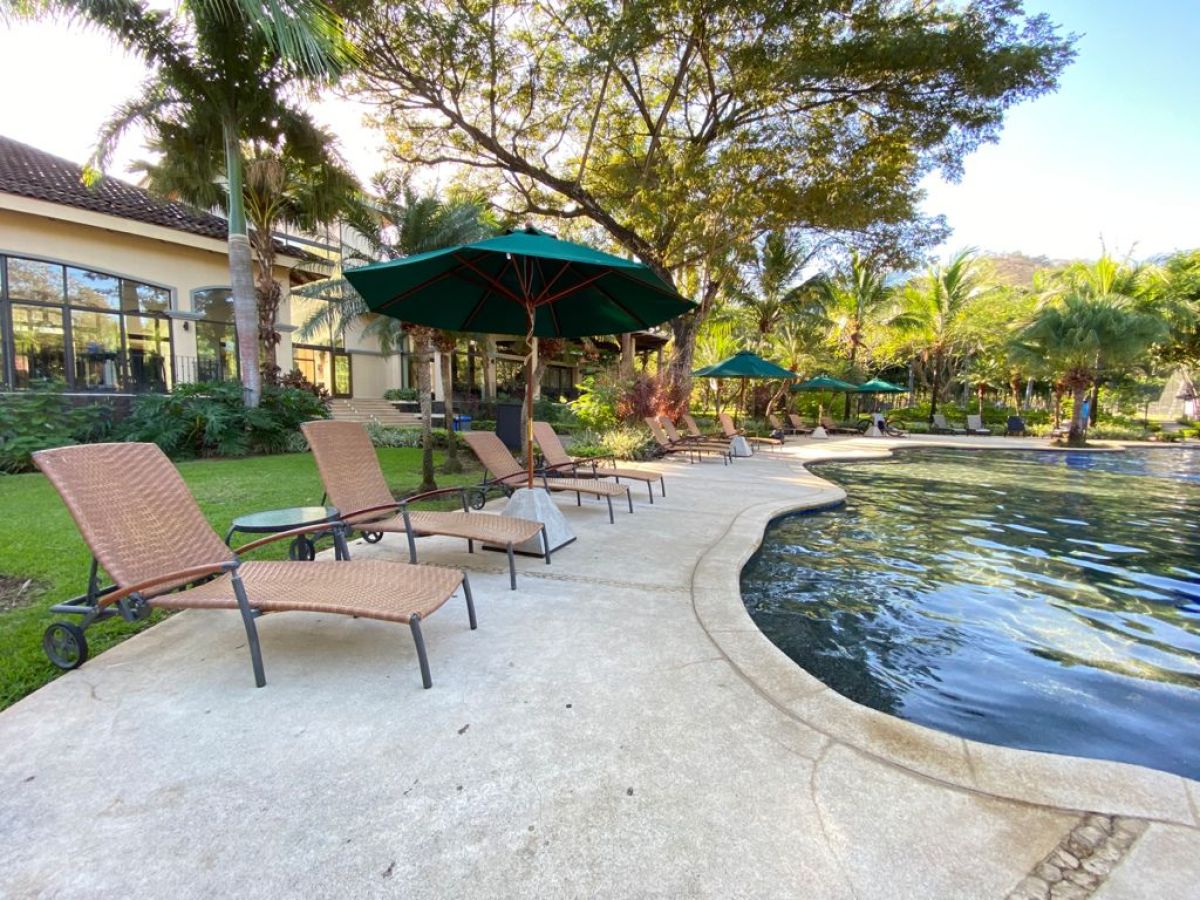 a couple of lawn chairs sitting next to a pool of water