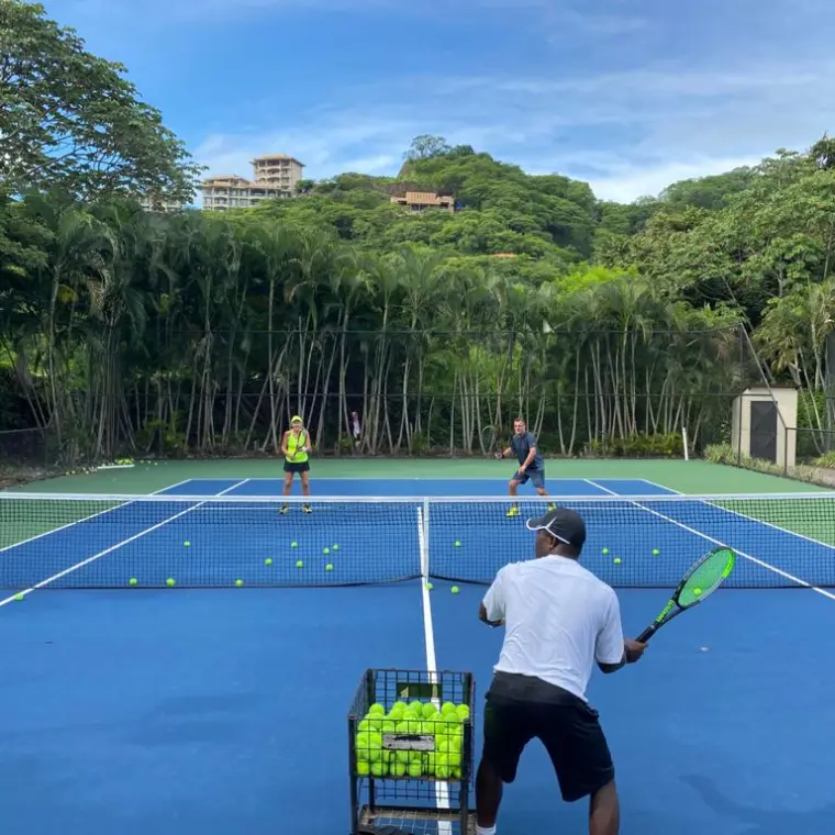 a group of people on a court with a racket